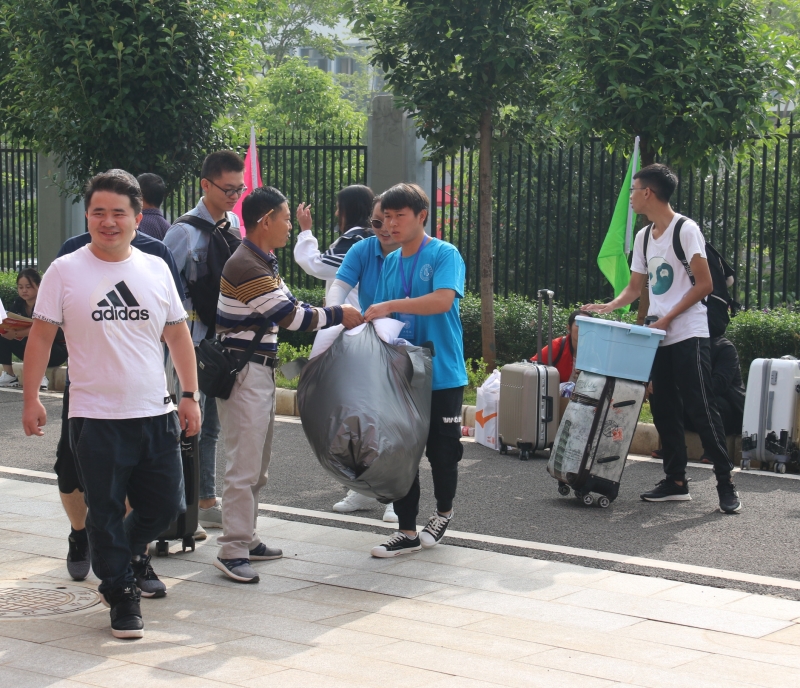 志愿者帮助新生拿行李.JPG 志愿者帮助新生拿行李.JPG