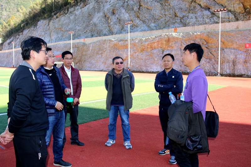 1.在体现“西畴精神”凿山而建的运动场前听取介绍.JPG 1.在体现“西畴精神”凿山而建的运动场前听取介绍.JPG